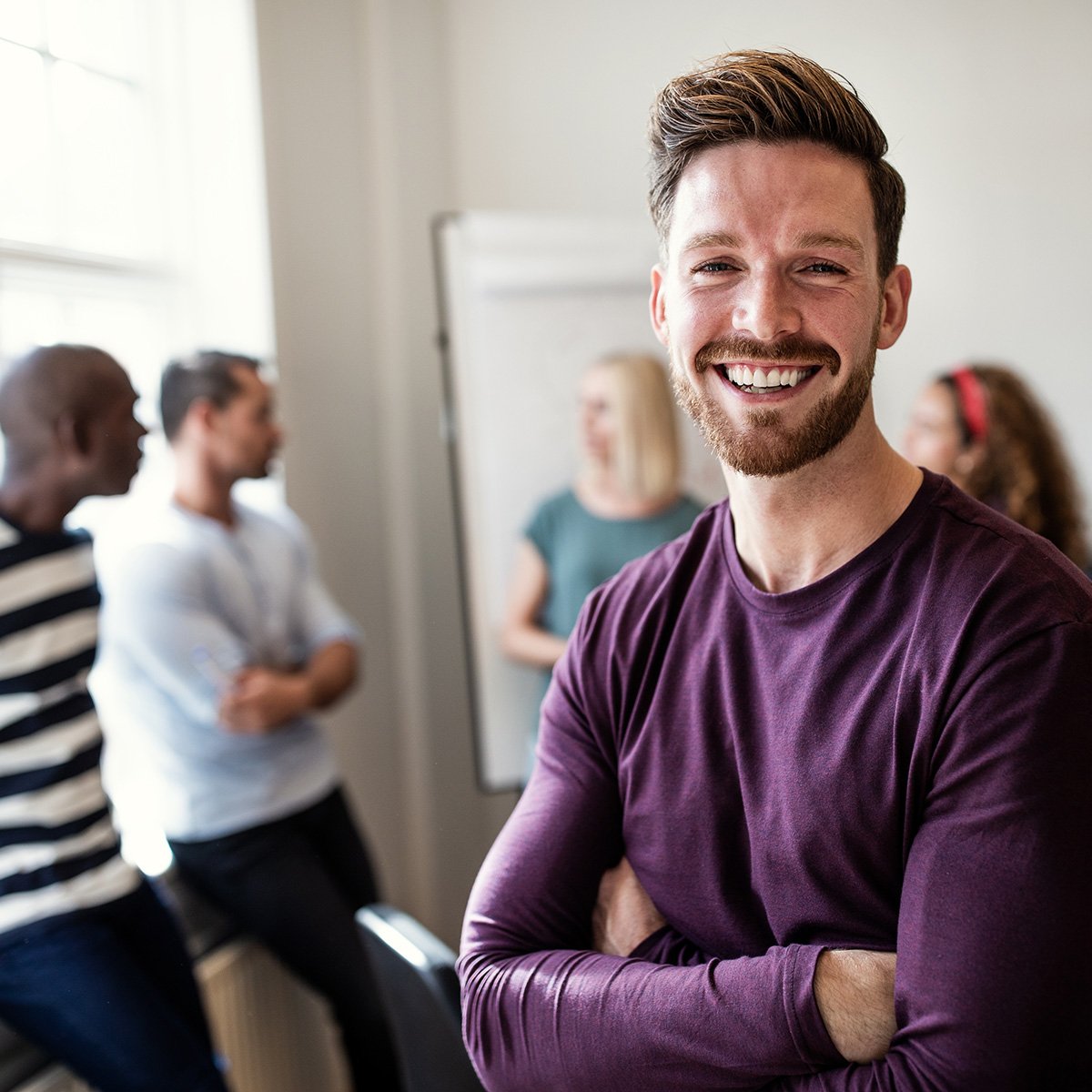friendly-male-coworker-smiling-at-the-office-square